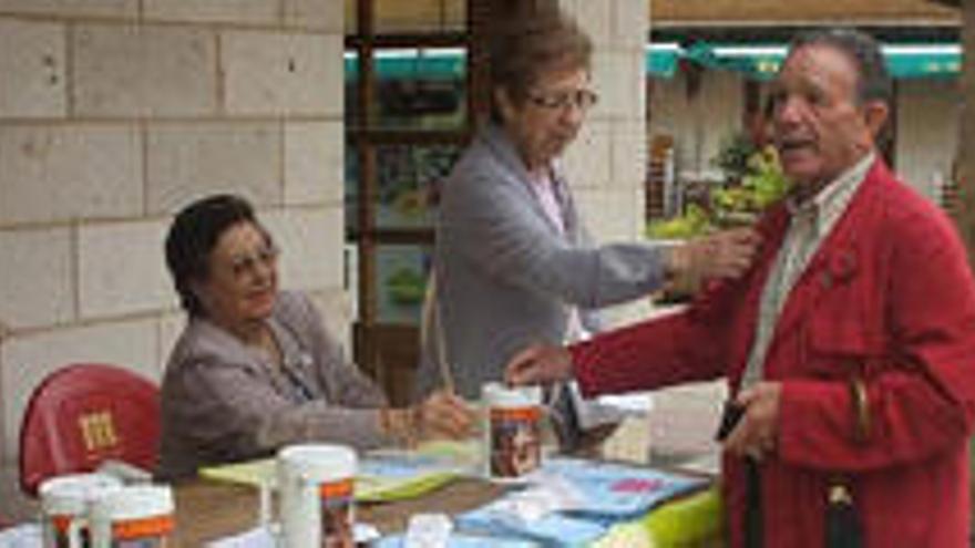 Un viandante colabora con la asociación de enfermos de Alzheimer con un donativo.