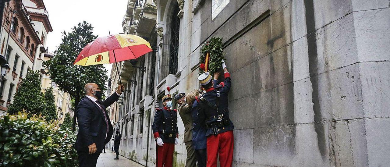 El coronel Alfonso Pardo de Santayana y Delia Losa colocan la corona con la ayuda de un soldado con el uniforme de la época del cabo Noval.