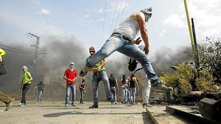 Palestins llançant pedres en enfrontaments ahir a Hebron