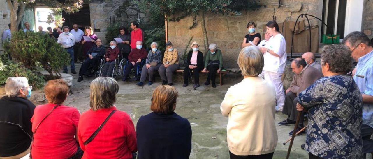 Vecinos y vecinas de Lodoselo en el local social del pueblo, concentrándose por el rural.   | // F. C.