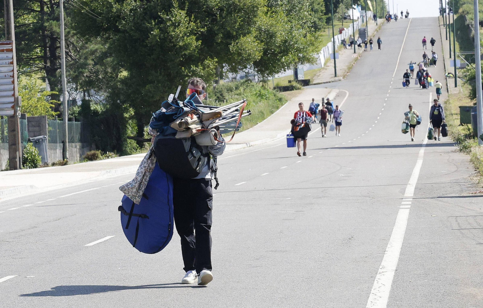 Vuelta a la realidad, paso a paso y mochila a cuestas: los campistas abandonan el Monte do Gozo
