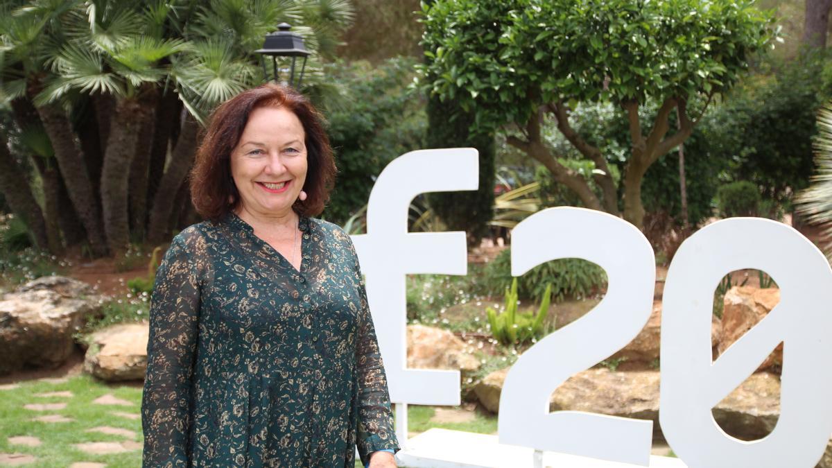 Rosa Castells, directora y creadora de Formentera20, posando junto al logotipo del evento