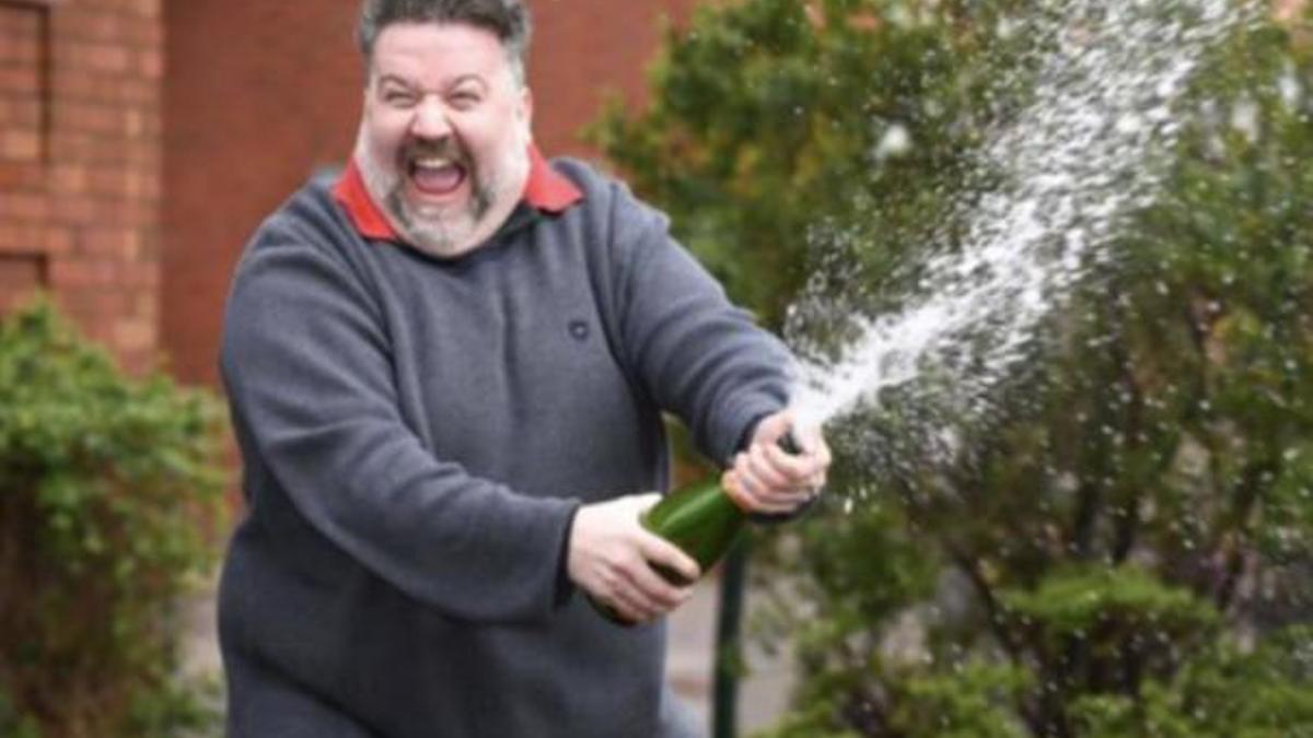 Dion Davies festeja su suerte descorchando una botella de champagne.