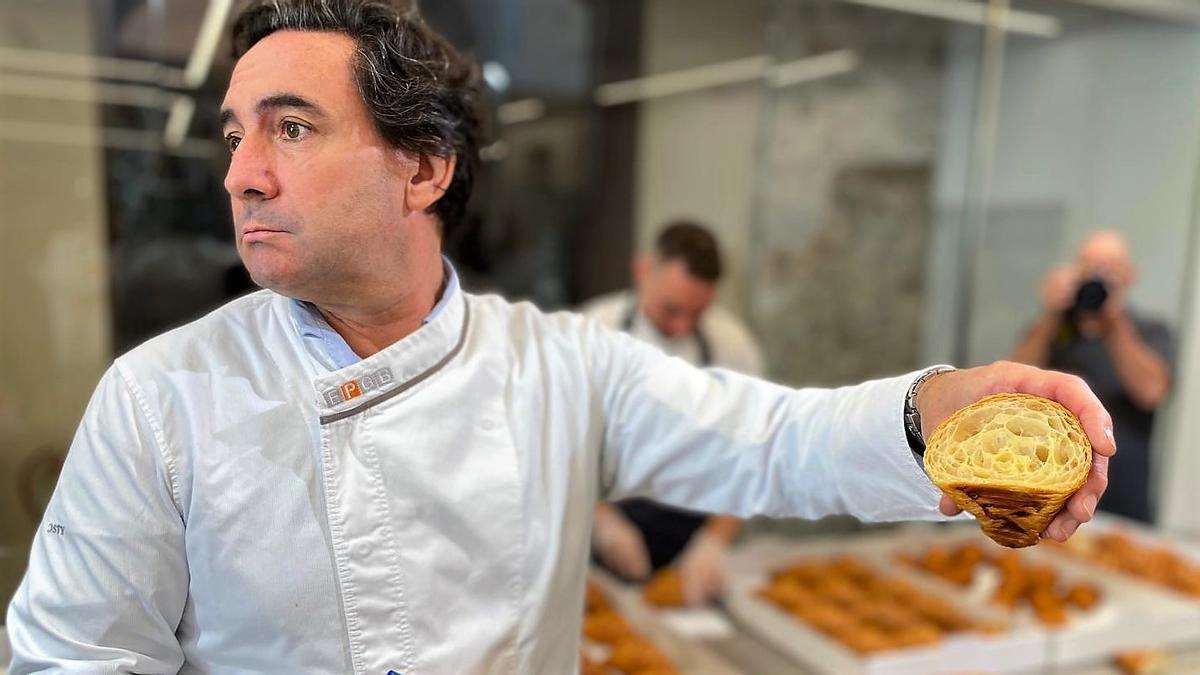 El pastelero Miguel Moreno, presidente del jurado que elige el mejor cruasán artesano de mantequilla de España 2025, muestra un cruasán cortado por la mitad para examinar su alveolado.