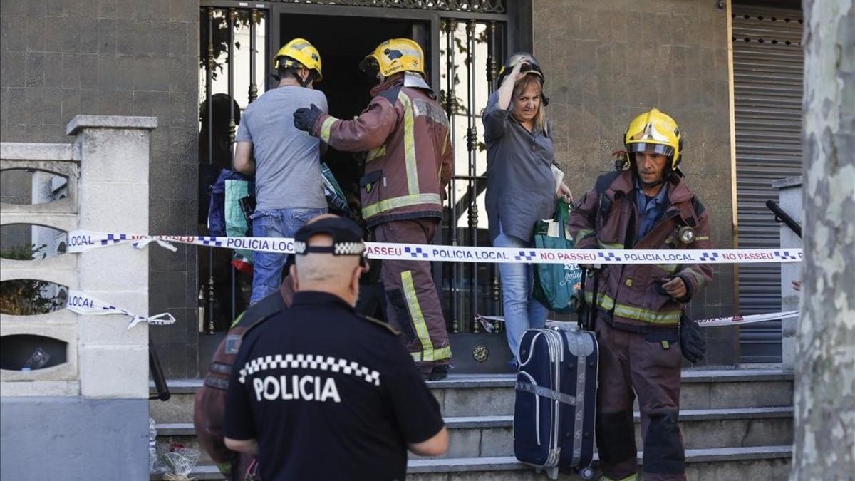 Uno de los vecinos sube acompañado por un bombero a su vivienda para recoger algunas pertenencias personales.