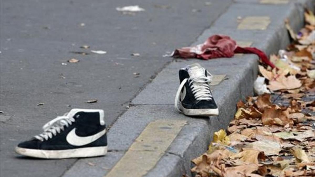 Unas zapatillas y una camiseta ensangrentada sobre la acera a las puertas de El Bataclan, ayer por la mañana.