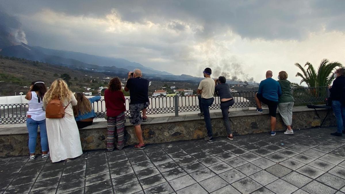 Curiosos viendo el volcán de La Palma desde el mirador de Tajuya.