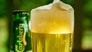 Archivo - FILED - 12 June 2018, North Rhine-Westphalia, Herdecke: A general view of a glass of beer and a can of Carlsberg beer on a table. Danish brewer Carlsberg on Thursday said it was expecting to deliver an organic operating profit decline of 10-15 p