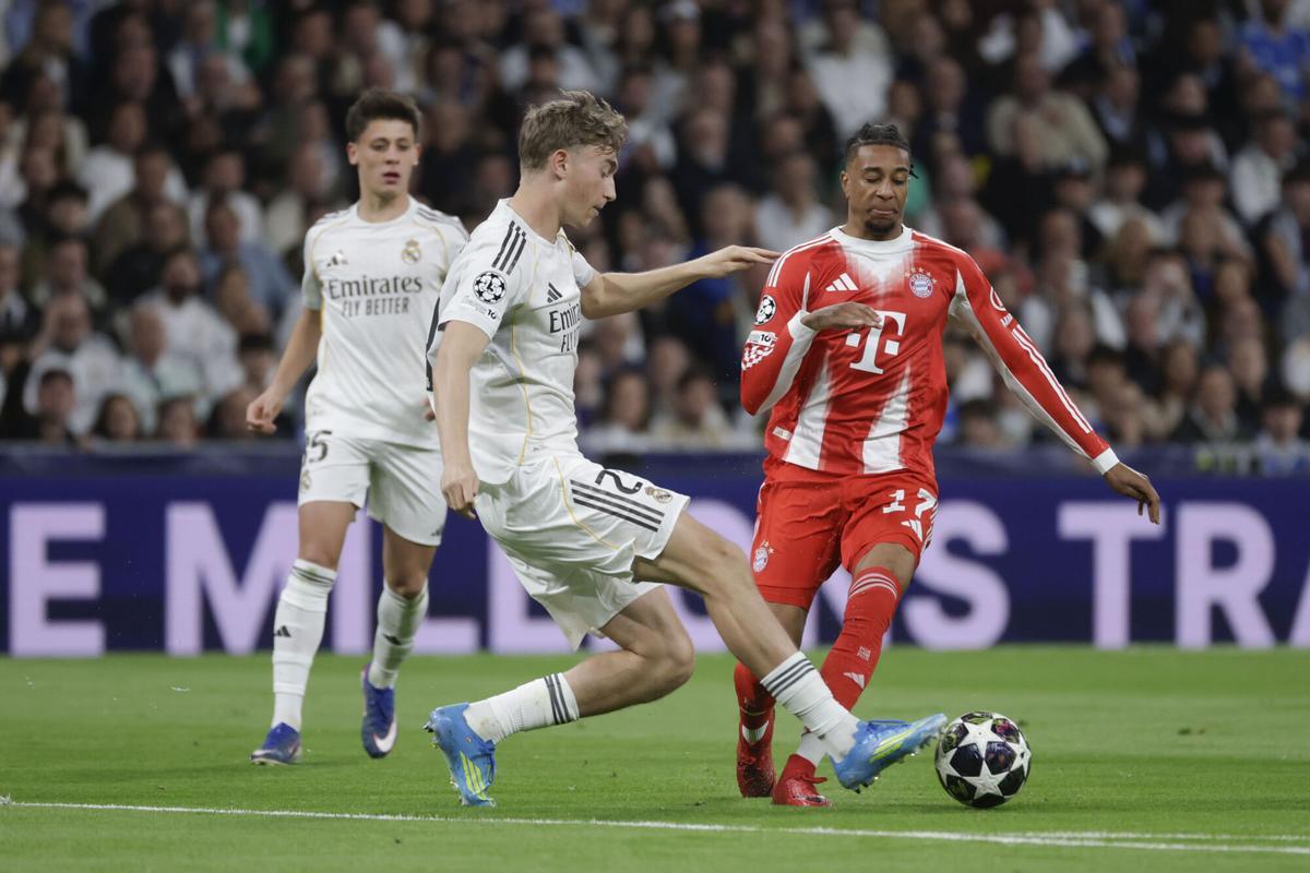 MADRID, 07/04/2026.- El defensa del Real Madrid, Dean Huijsen (i), despeja el balón ante el delantero francés del Bayern Munich, Michael Olise, durante el encuentro correspondiente a la ida de los cuartos de final de la Liga de Campeones que disputan este martes Real Madrid y Bayern Munich en el estadio Santiago Bernabéu, en Madrid. EFE/Juanjo Martín.