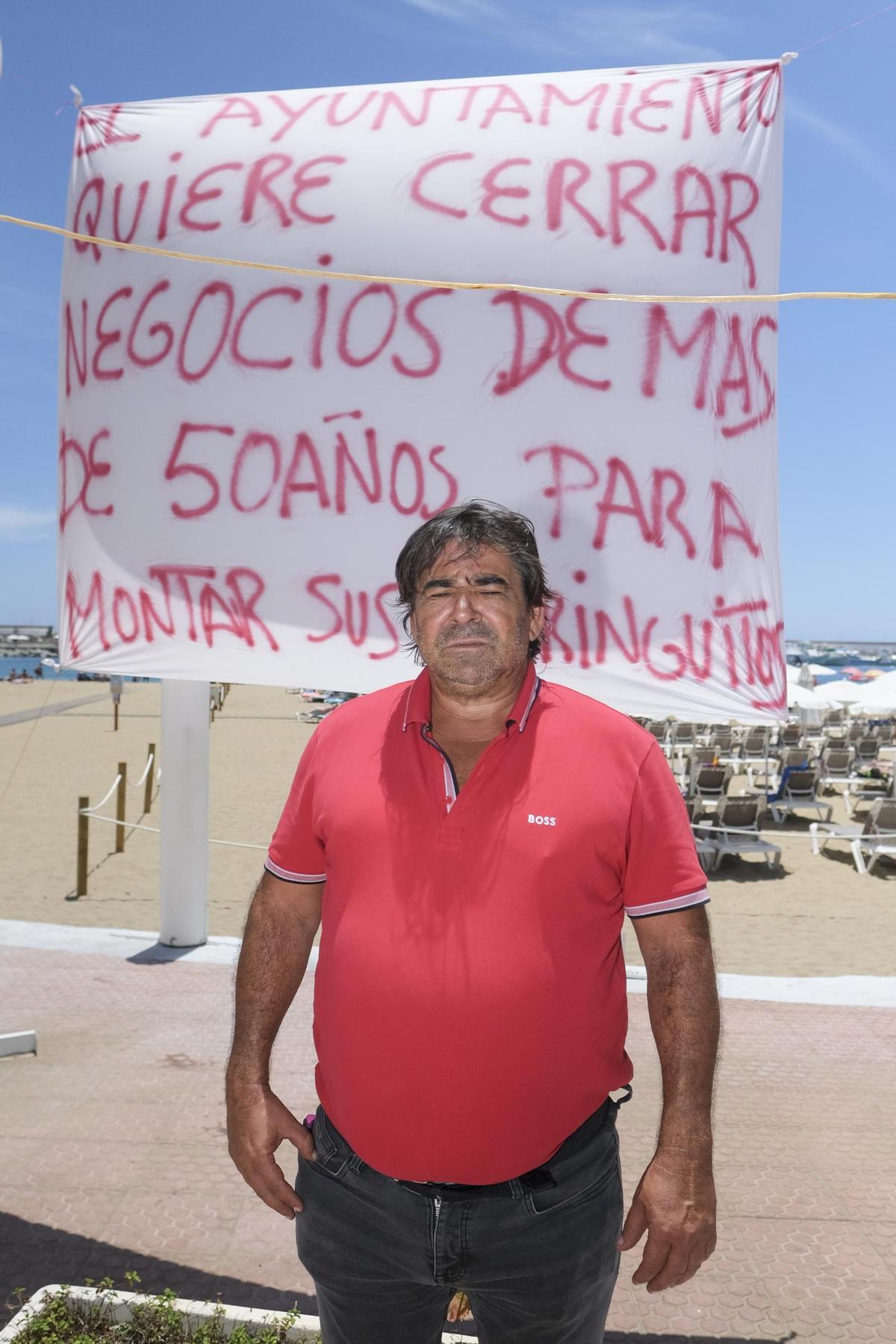 Pablo González ante las pancartas que tiene delante de sus negcios.
