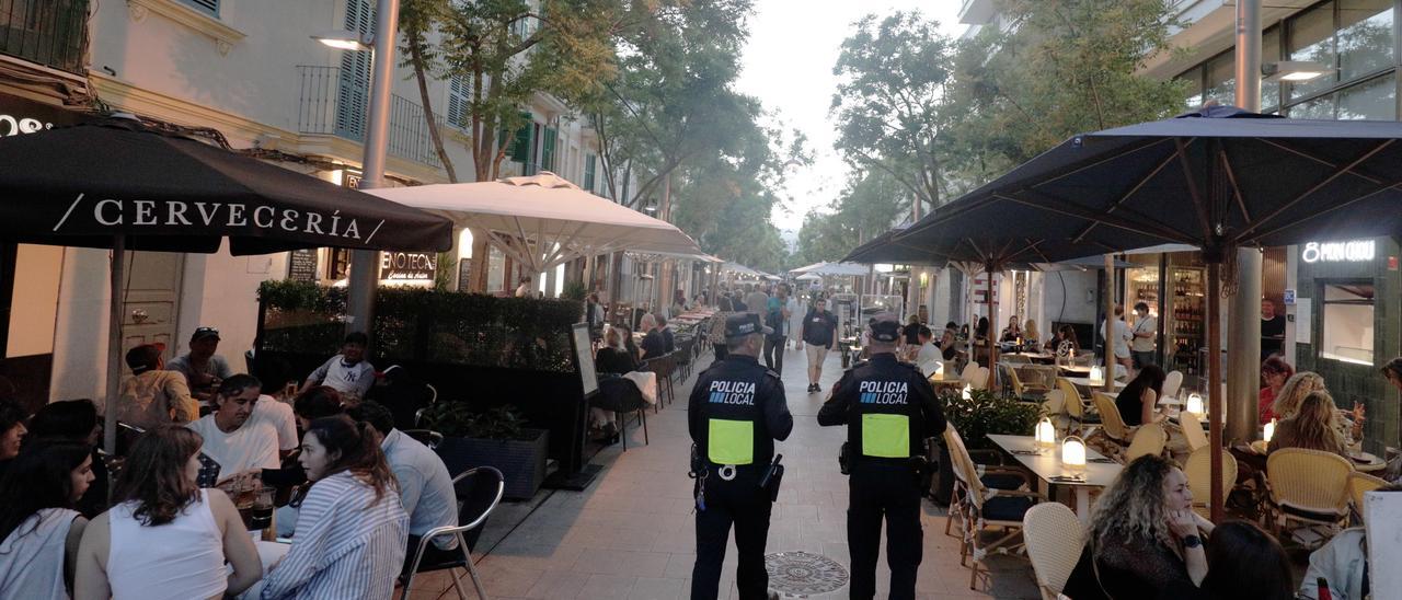 Dos agentes caminan entre las terrazas de call Fàbrica.