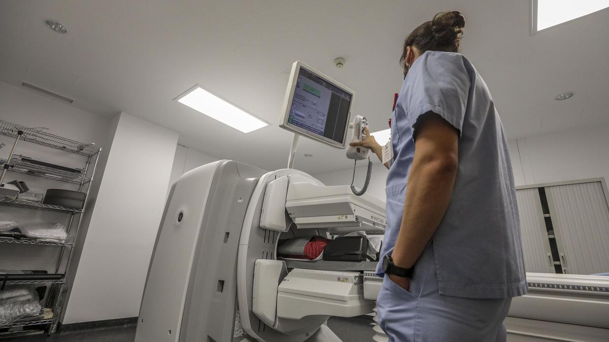 Un profesional del servicio de Medicina Nuclear del Hospital Vinalopó maneja el nuevo SPECT-TAC para realizar la prueba a un hombre.