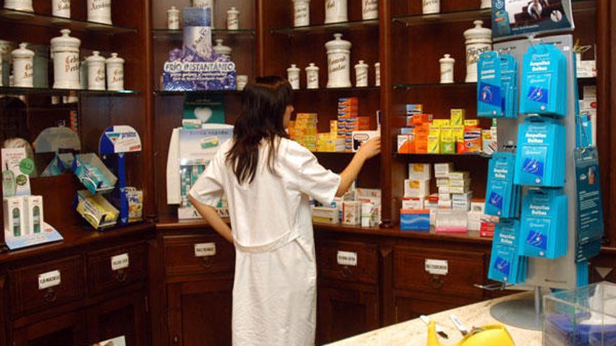 Una farmacéutica coloca fármacos en su botica en Lalín.