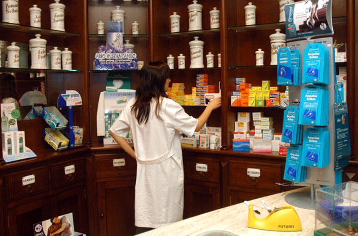 Una farmacéutica coloca fármacos en su botica en Lalín.