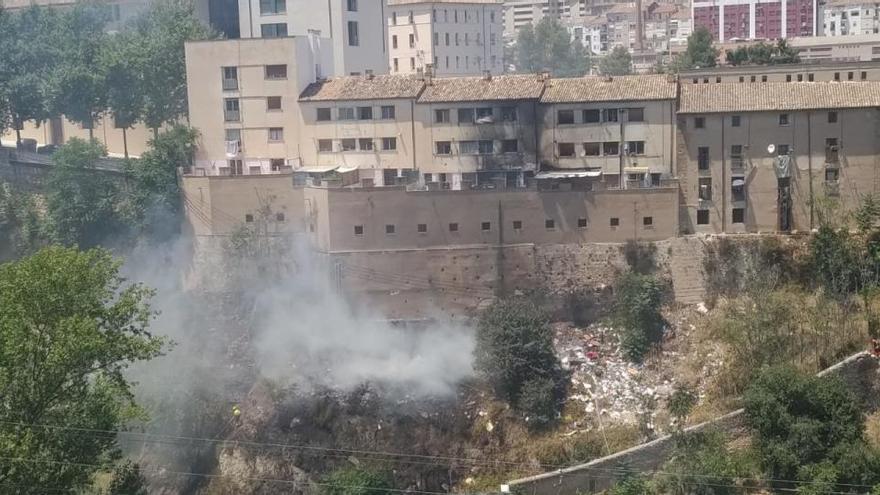 El incendio en el barranco ya casi apagado y la vivienda afectada.