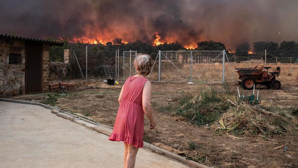 Una mujer observa el avance de las llamas en Ferreruela. | Emilio Fraile |  EMILIO FRAILE