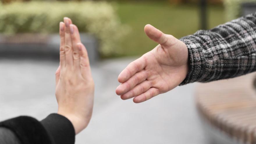 Dos manos, una femenina y otra masculina, mostrando rechazo.