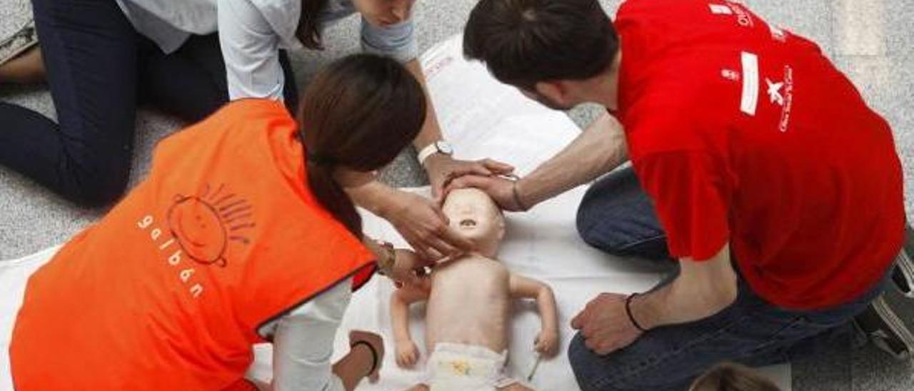 Expertos durante un taller de reanimación, con un muñeco que simula un bebé.