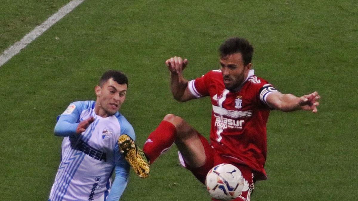 El albinegro Carlos David gana un duelo en el partido frente al Málaga.