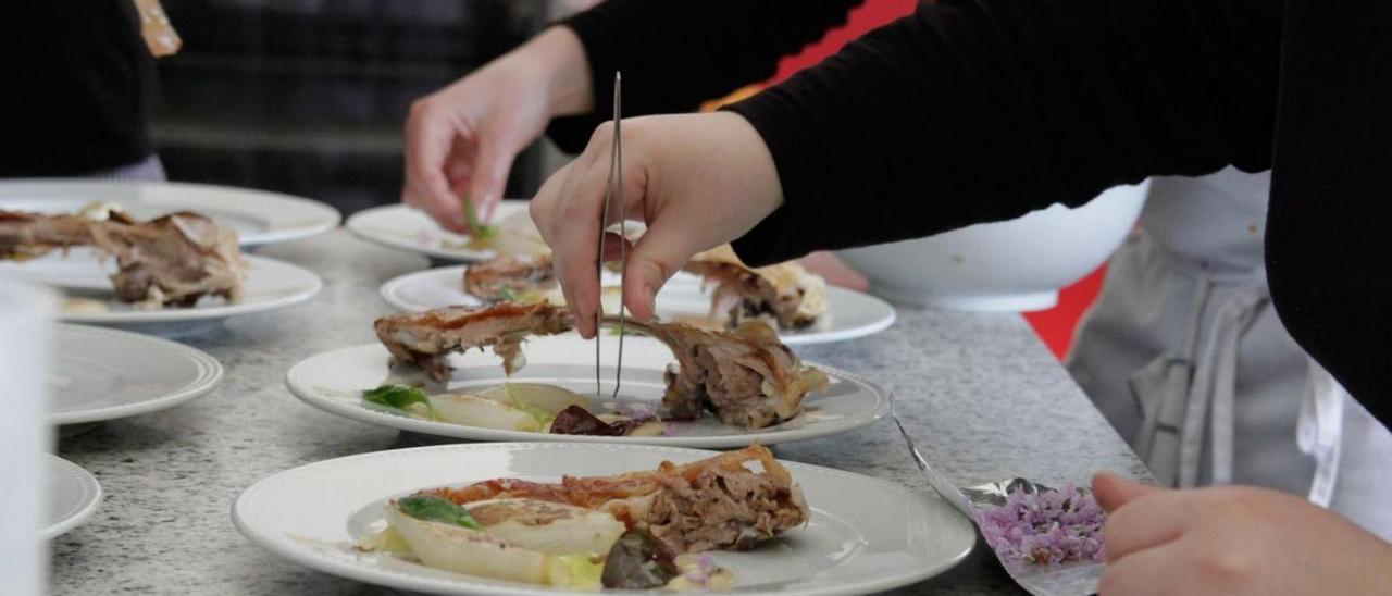 Cocineros preparando platos de lechazo. | Jose Luis Fernández