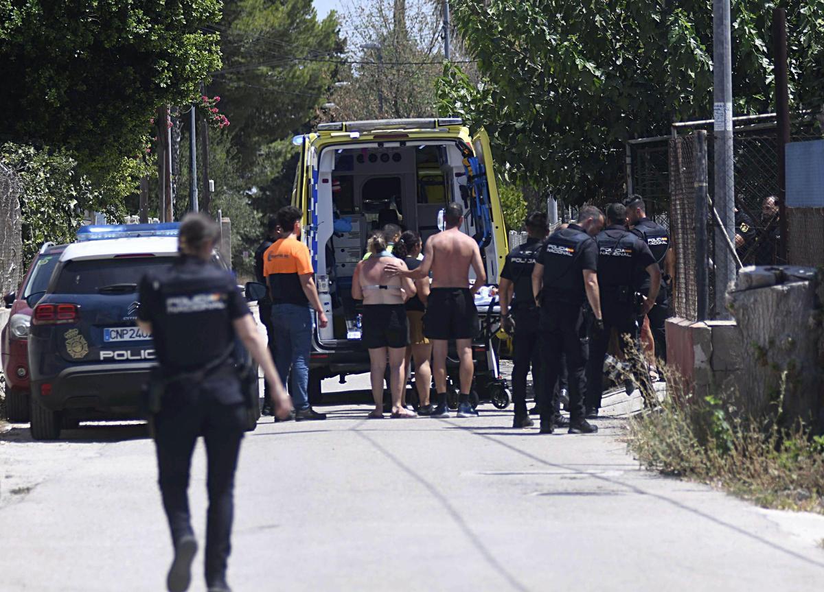 Familiares de uno de los apuñalados lo acompañan a la ambulancia junto a agentes de la Policía Nacional en la mañana del miércoles en el Barrio del Progreso