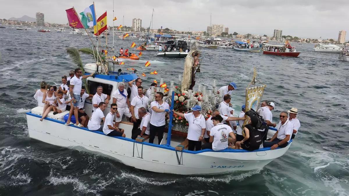 La imagen de la patrona navega junto a las embarcaciones en su romería.