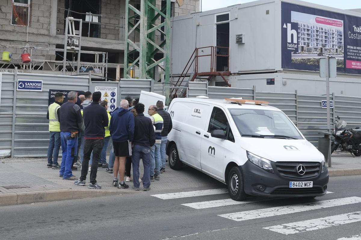Compañeros de la víctima y trabajadores de la obra, en el exterior del inmueble