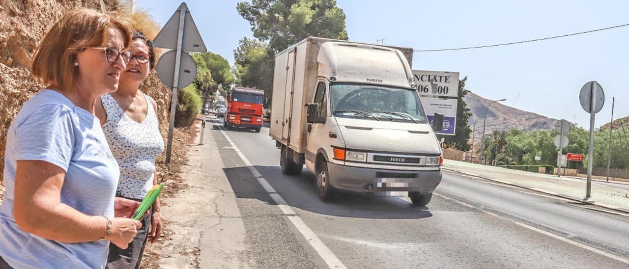 Dos vecinas del barrio de Ciudad Jardín esperan en el estrecho arcén a poder cruzar con seguridad al otro lado de la N-340.