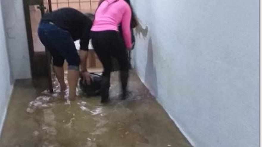 Vecinos de Moncada achicando agua de su vivienda ayer a ultima hora de la tarde,