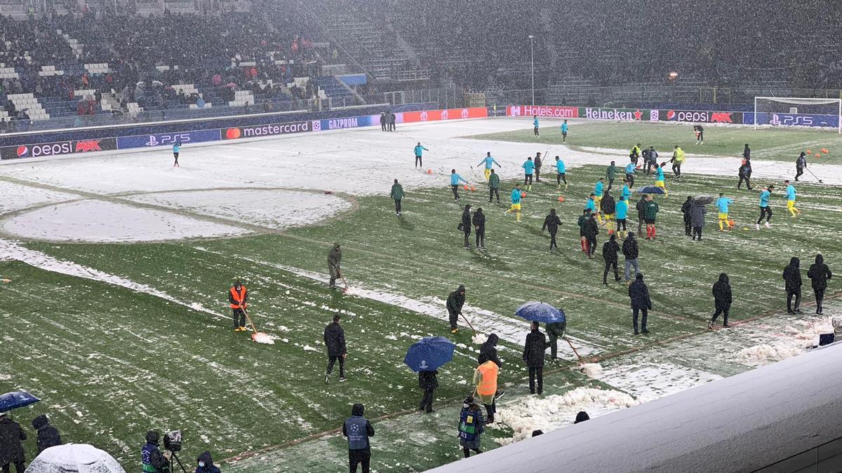 Los futbolistas del Villarreal calientan sobre el césped nevado de Bérgamo.