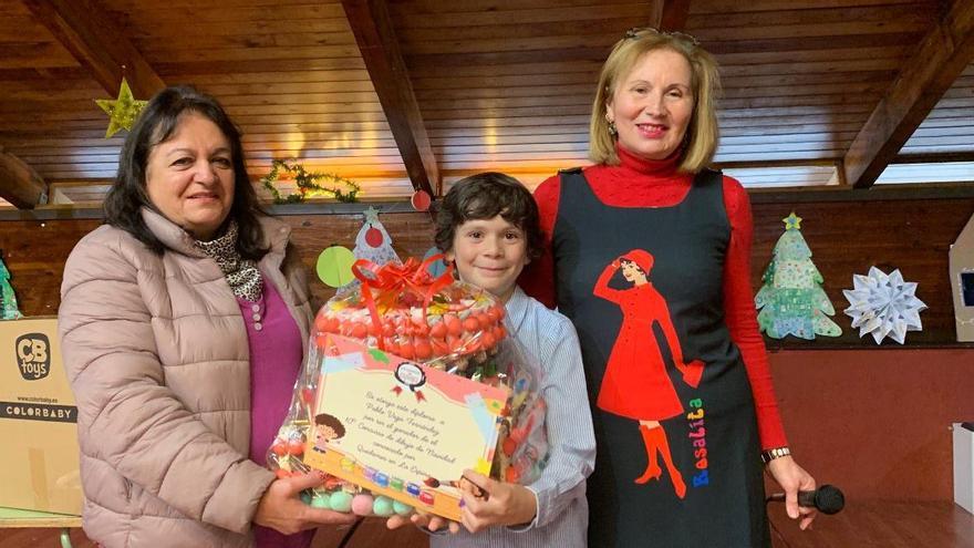 El ganador de décimo concurso de dibujo navideño de La Espina, Pablo Vega (en el centro), junto a Marisa Menéndez y Marité de Oso.