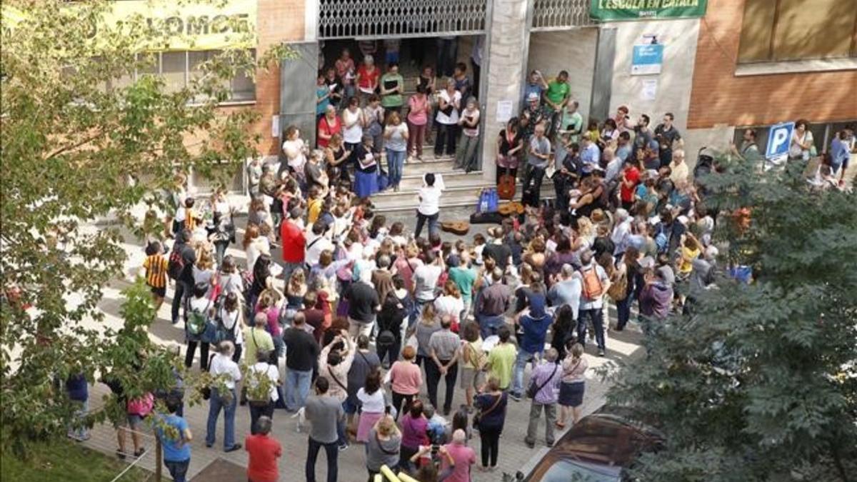 Un grupo de padres y vecinos cantan Els Segadors en la puerta del colegio El Sagrer de Barcelona
