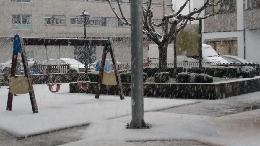 Parque infantil de Teixeiro cubierto de nieve.