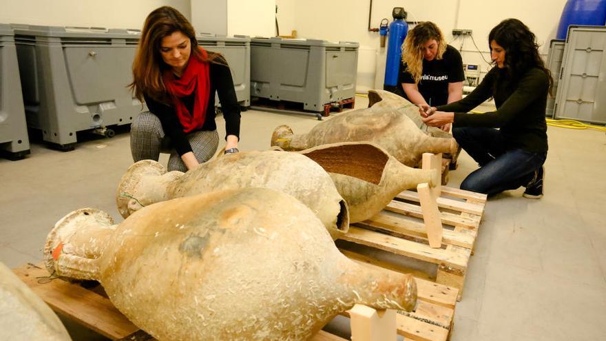 Tres de las trabajadoras de Vilamuseu junto a varias ánforas localizadas en el pecio Bou Ferrer, ayer, en el museo de La Vila.