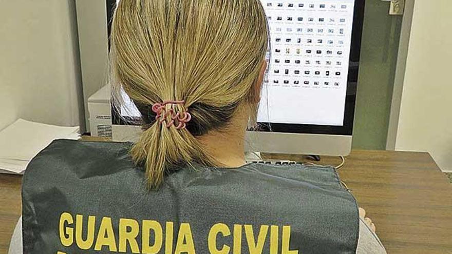 Una agente de la PolicÃ­a Judicial de la Guardia Civil investiga ante un ordenador.