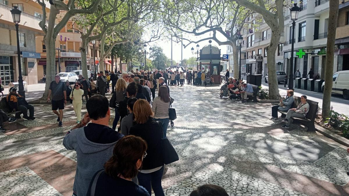 La cola para adquirir las sillas del Santo Entierro, con el quiosco de l'Amorosa al fondo.