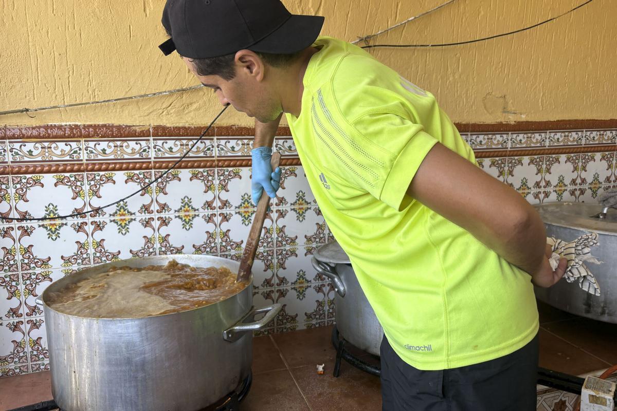 CEUTA, 11/08/2026.- En la puerta de la casa de Sabah, en Los Rosales, una de las barriadas de la periferia de Ceuta, los migrantes empiezan a llegar hasta dos horas antes de que se reparta la comida, apretándose pegados a la pared para resguardarse en la única franja de sombra que hay en toda la calle. Desde el primer día de la crisis migratoria, el hogar de Sabah dejó de ser una residencia privada para transformarse en un punto de socorro. En la imagen un voluntario cocina en el domicilio de Sabah. EFE/Laura Rincón