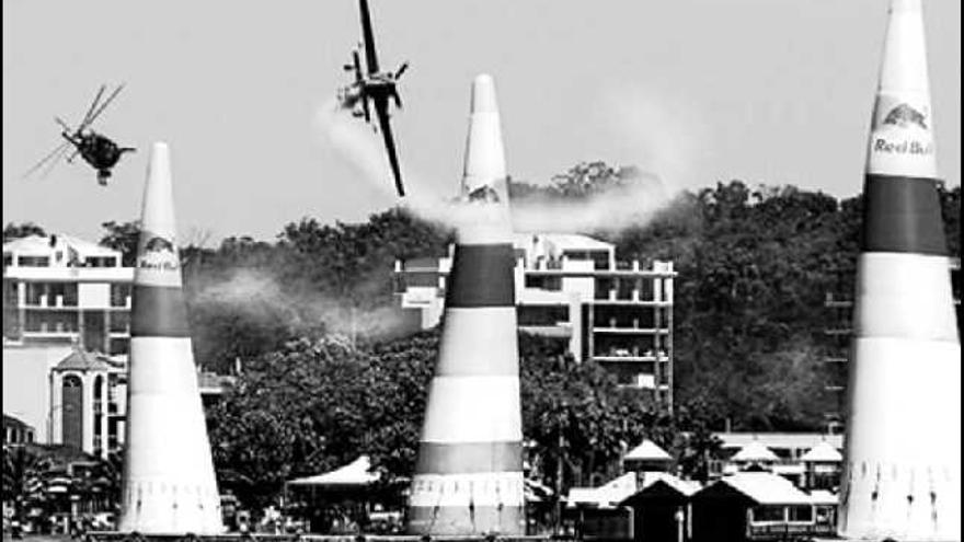 acrobacias. Un avión cruza los pilones instalados en la playa en una de las pruebas de la Red Bull Air Race.