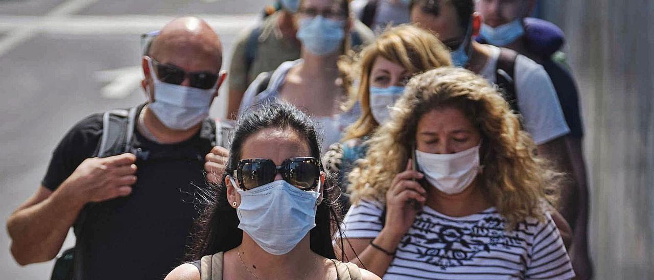 Un grupo de personas camina por una vía de Arona.