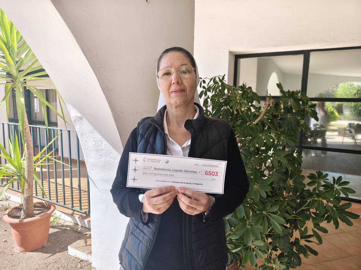 La hermana Rocío Botero sostiene el cheque recibido en nombre del colegio Puertapalma de Badajoz.