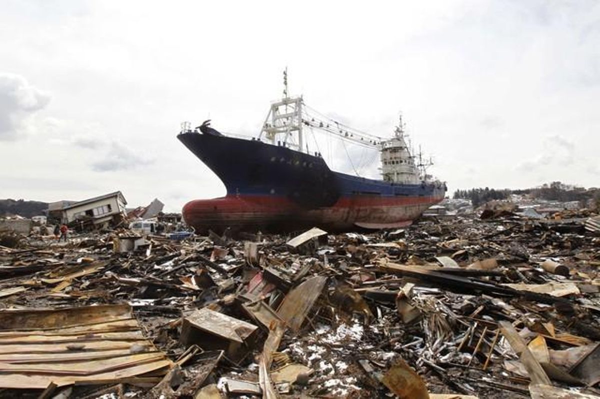 Un vaixell portat terra endins pel tsunami descansa ara, lluny de les onades, a la devastada zona de Kesennuma.