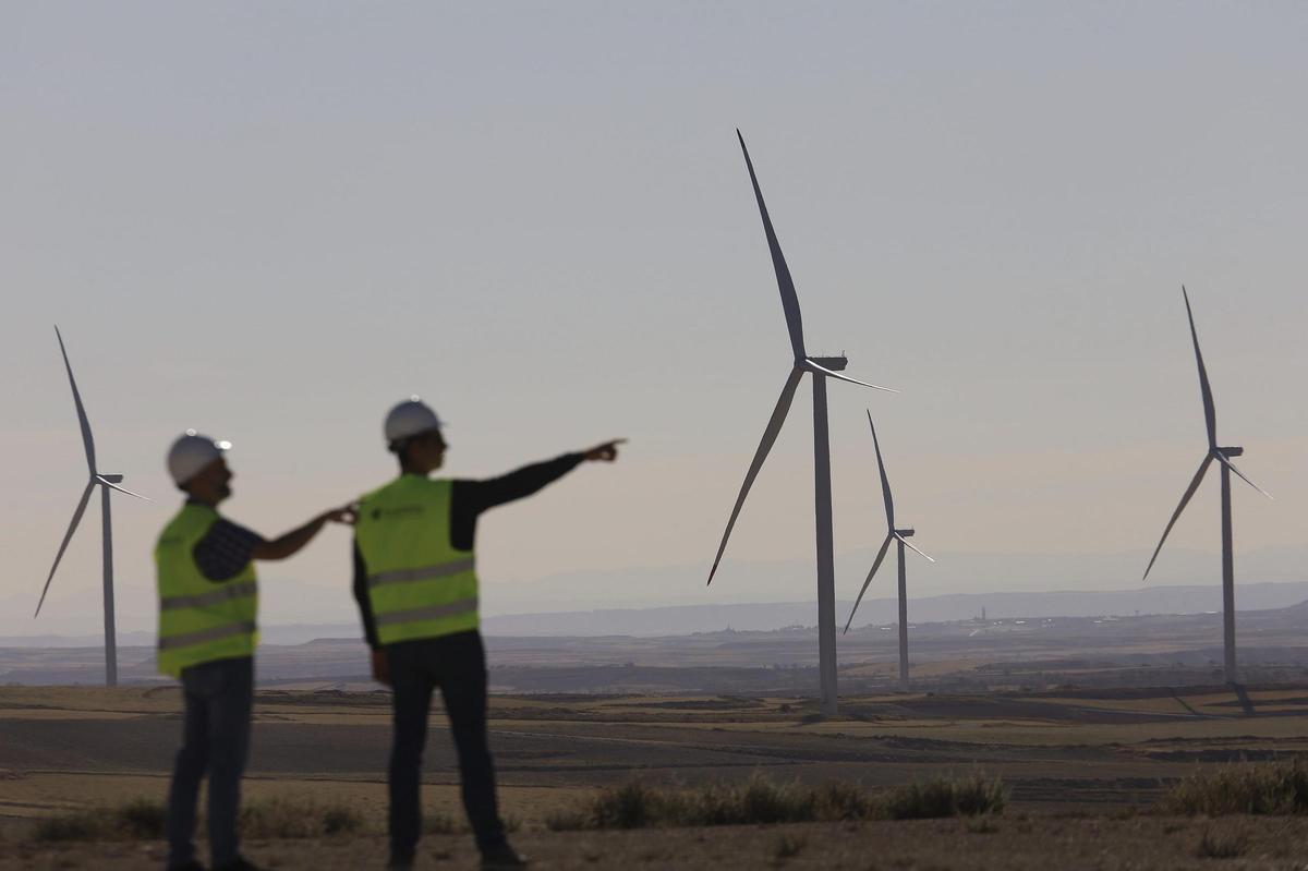 Dos trabajadores de Forestalia, junto a varios aerogeneradores instalados en un municipio de Zaragoza