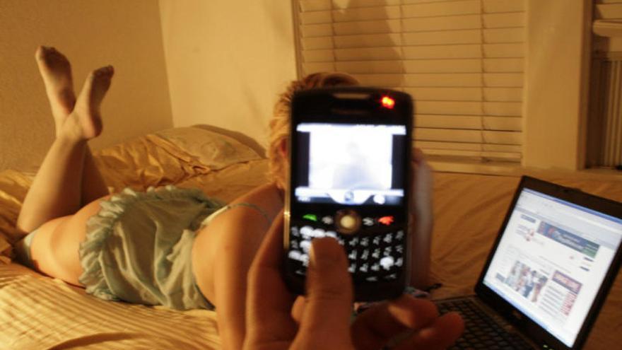 Un usuario graba a una joven un con teléfono móvil