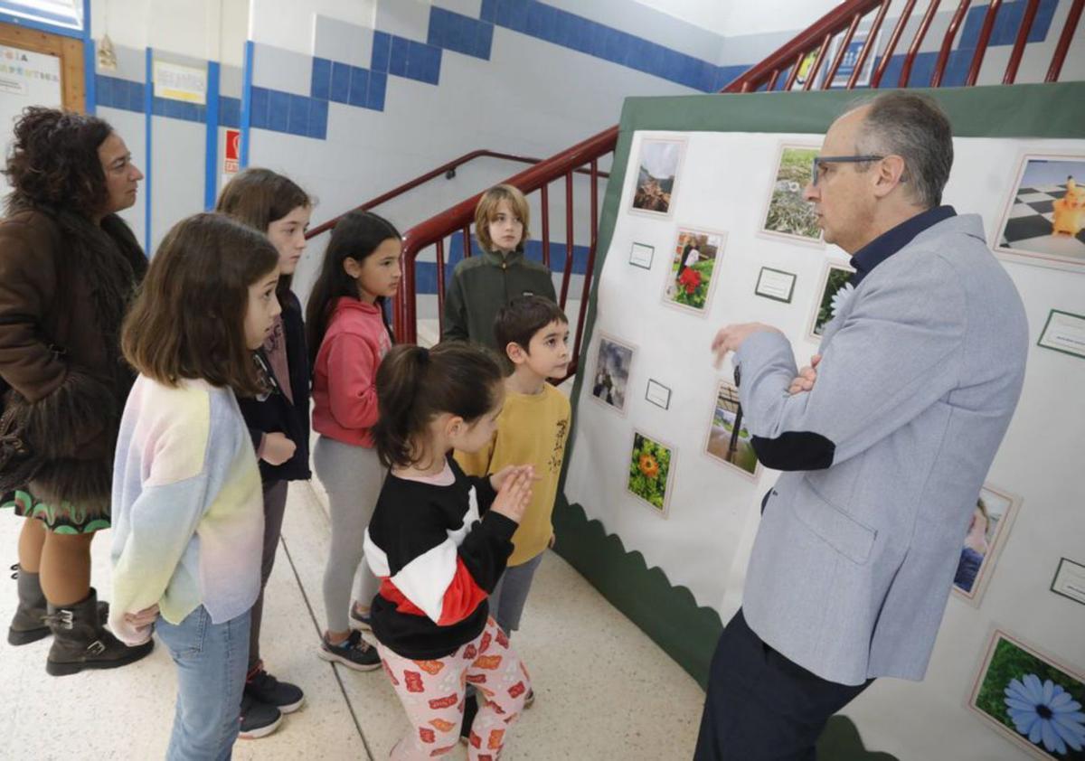 El concejal Juan Carlos Guerrero conversa con los alumnos del curso de fotografía ante su exposición. | Ricardo Solís