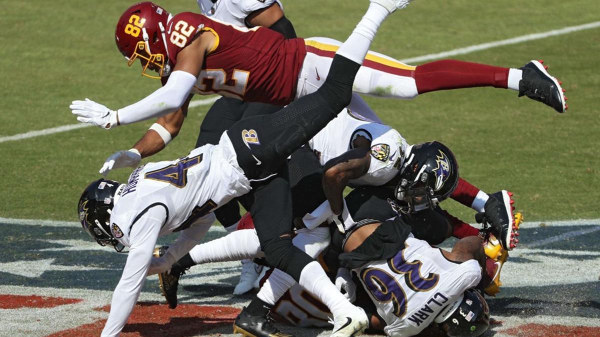 El receptor Dontrelle Inman # 80 del equipo de fútbol de Washington es placado por el safety Chuck Clark # 36 de los Baltimore Ravens durante la primera mitad en el FedExField.