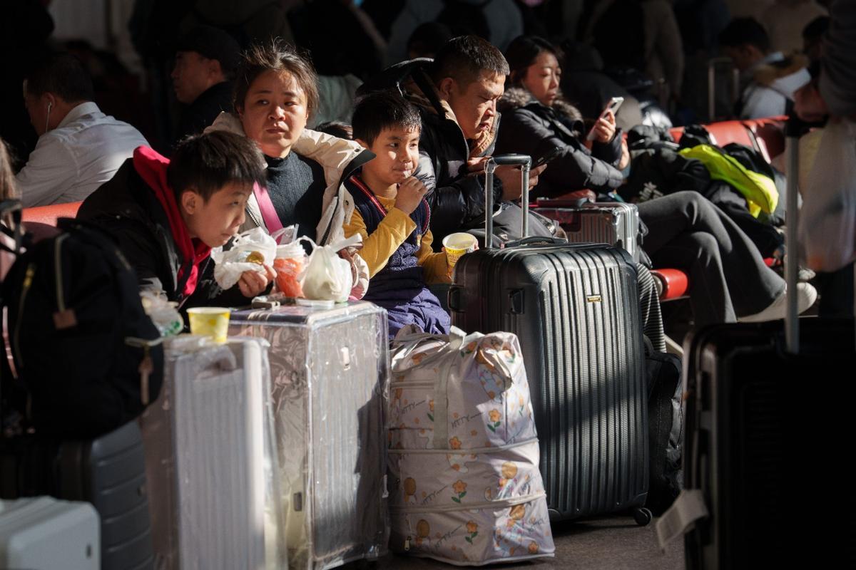 Pasajeros aguardan en una estación de Pekín antes de abordar un tren hacia sus hogares familiares con motivo de las vacaciones del año nuevo lunar.