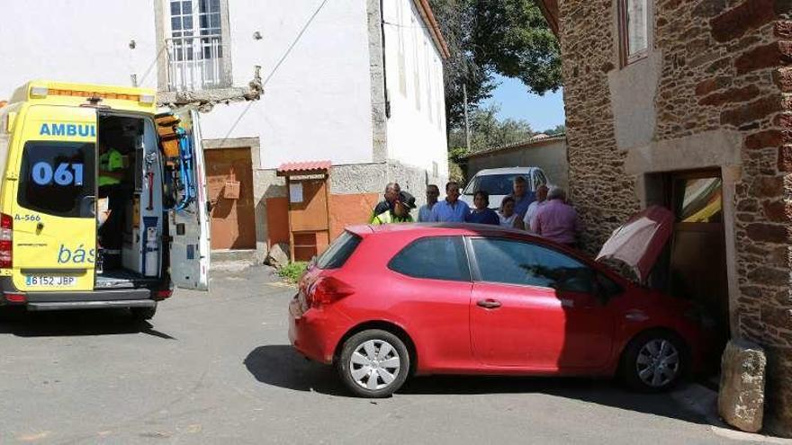 Varios vecinos de la localidad, junto al coche siniestrado. // Bernabé