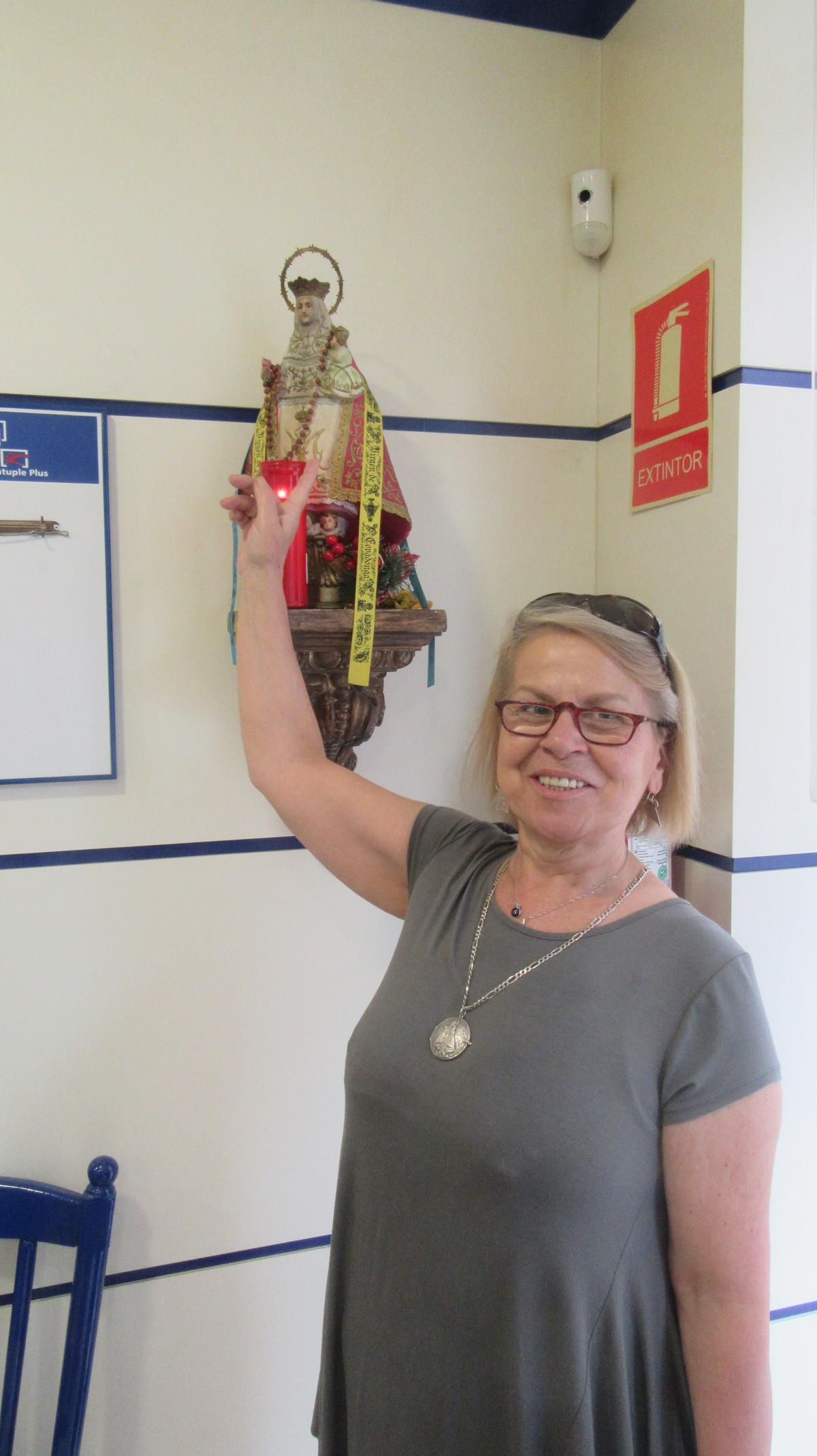 La lotera, con la imagen de la Santina a la que agradeció el premio.