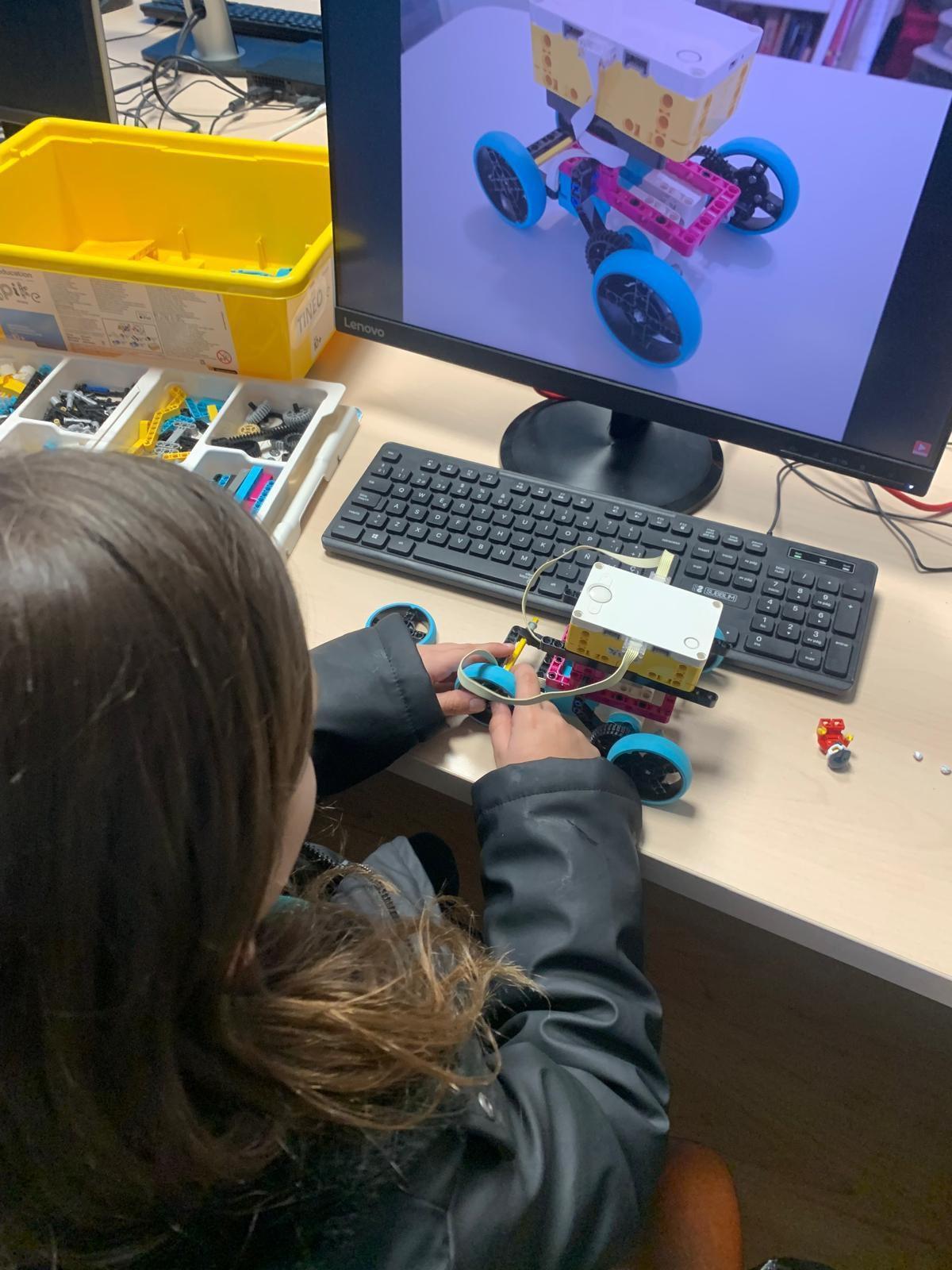 Una niña trabaja en la creación de un robot.