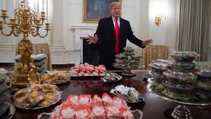 Trump ante las hamburguesas que encargó para recibir a un equipo de fútbol americano.
